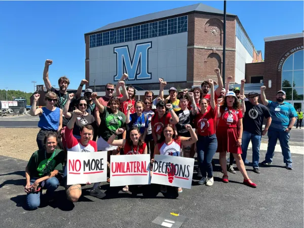 UMaine union members hold signs saying "no more unilateral decisions"